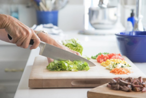 Close up of someone cutting lettuce on a cutting board